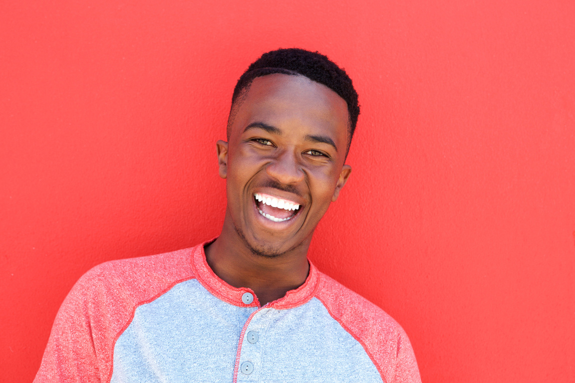 Close up Smiling Young African American Man against Red Background