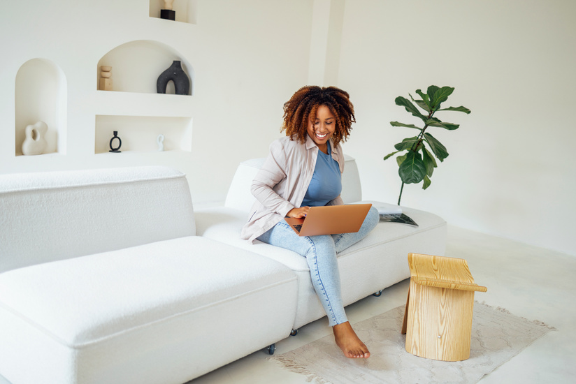 Overjoyed young african american woman, holding laptop