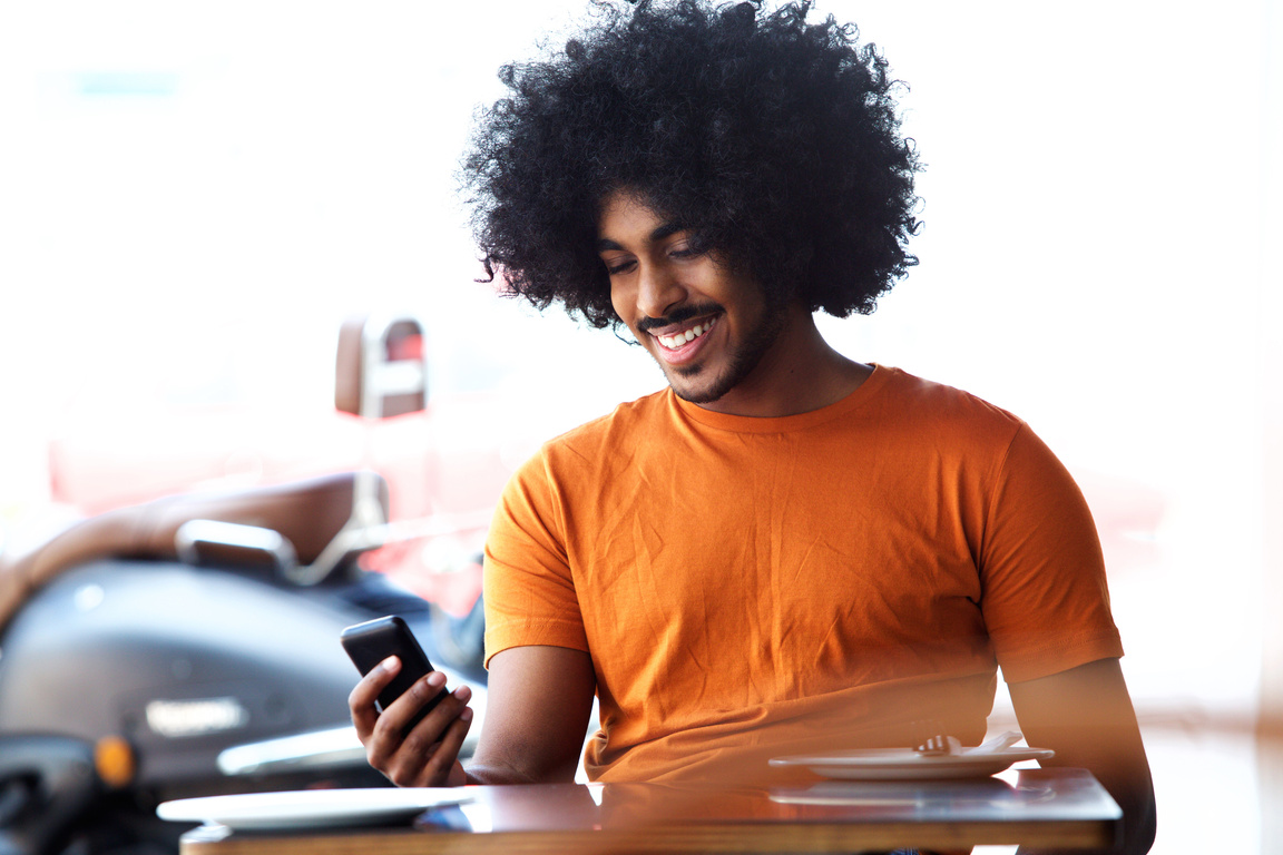 Happy Smiling Black Man Looking at Mobile Phone