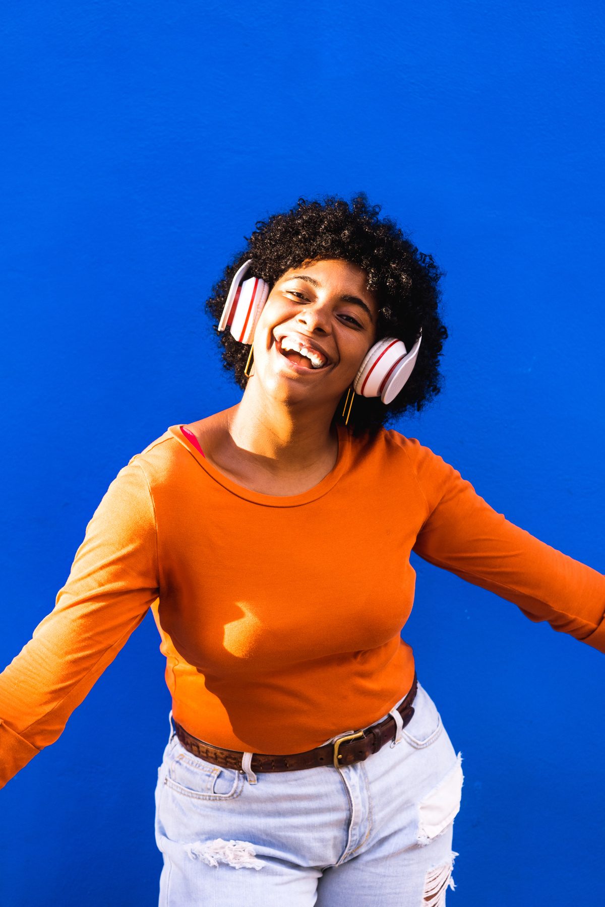 Portrait of a Happy Lady with Headphones on Blue Background